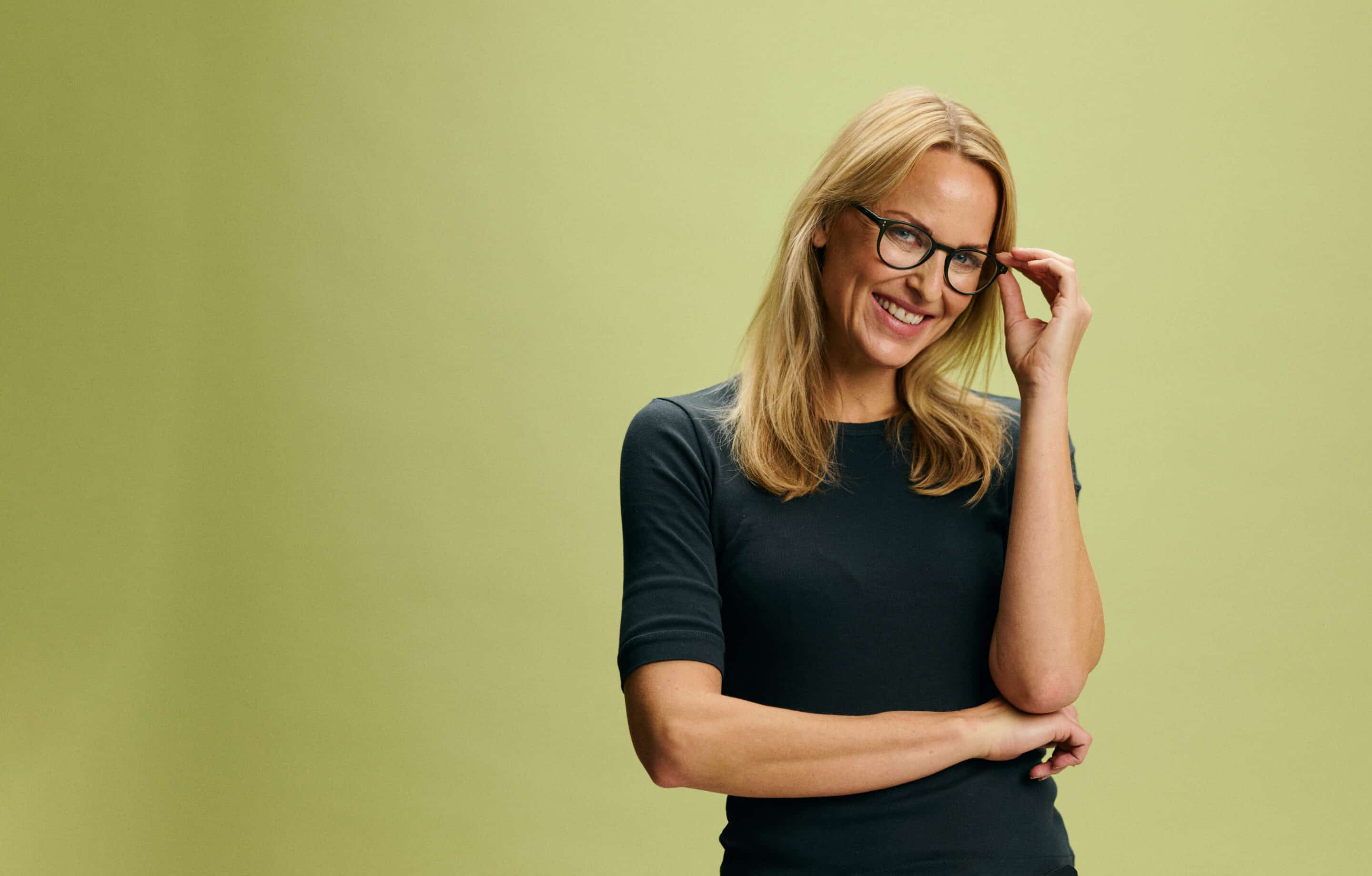 Blond woman in black t-shirt with glasses on